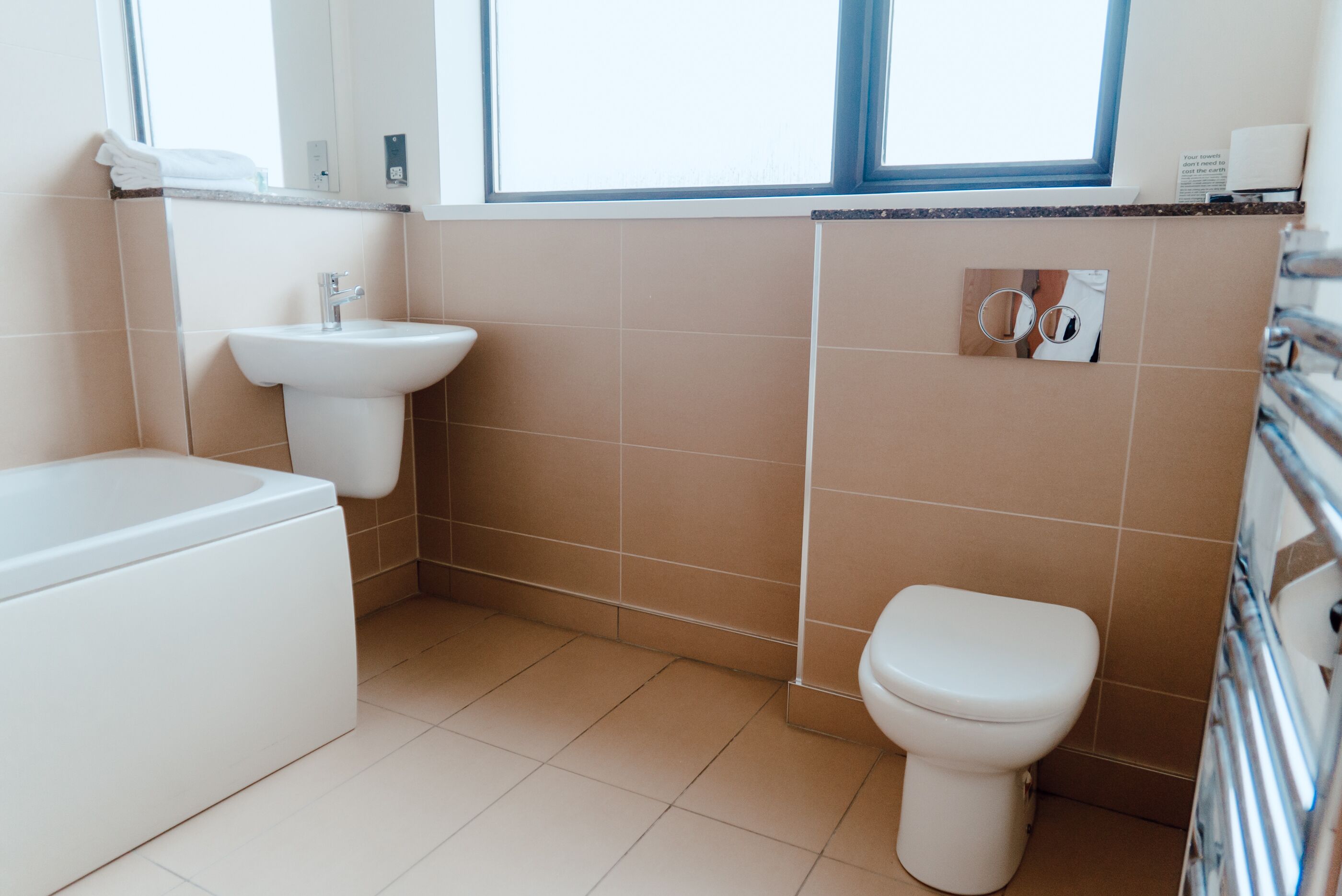 A modern bathroom with a bathtub, sink, and toilet.