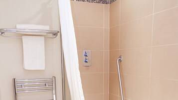 Un baño moderno con cabina de ducha, una bañera blanca, un perchero y una barra de apoyo.