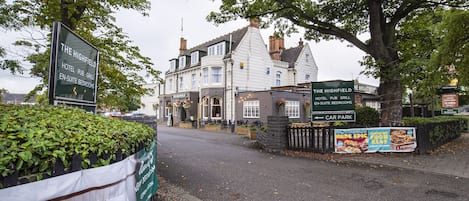 A traditional pub with a sign indicating it offers en-suite bedrooms and a car park.