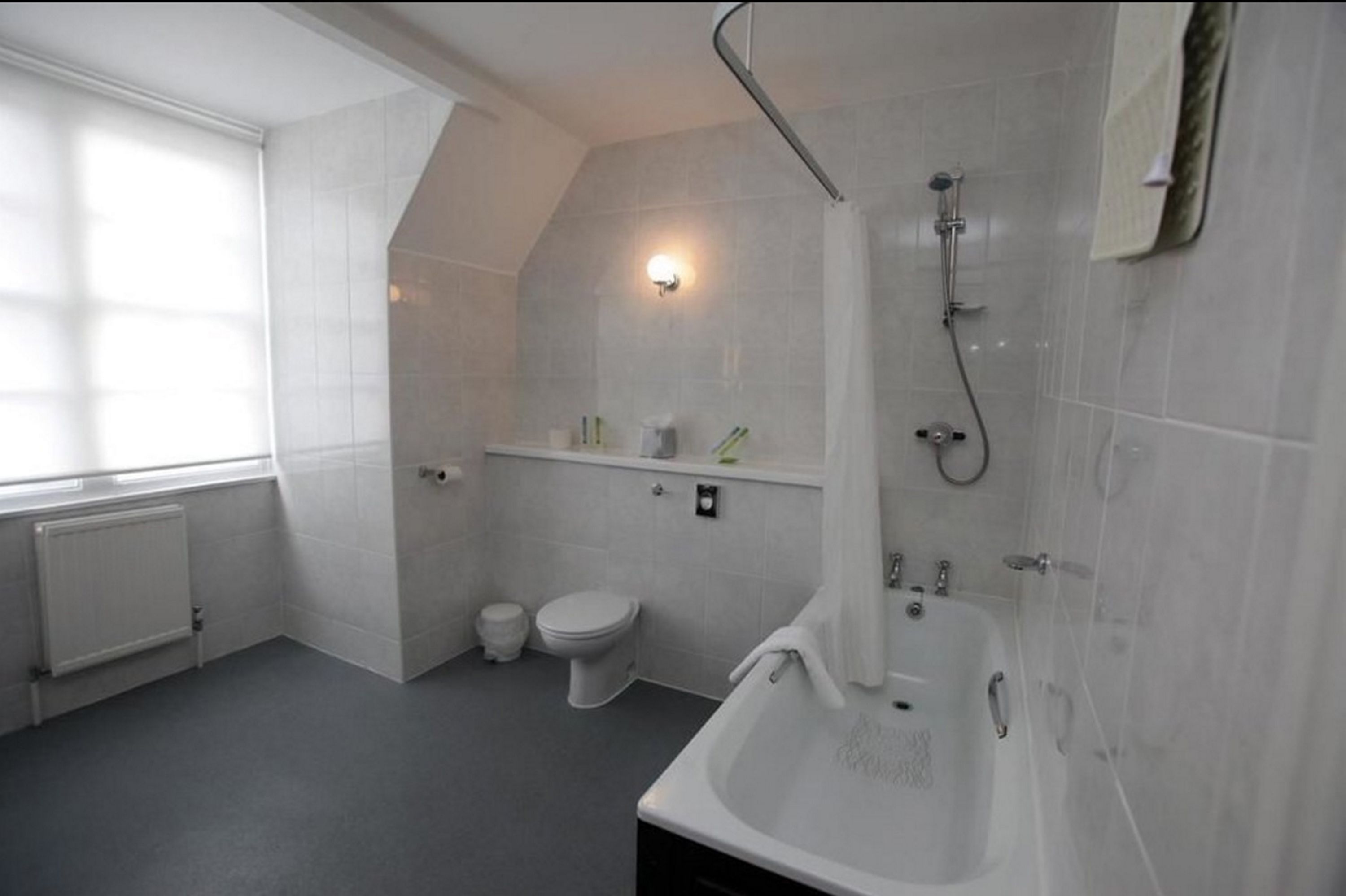 A modern bathroom with a shower, toilet, and bathtub.