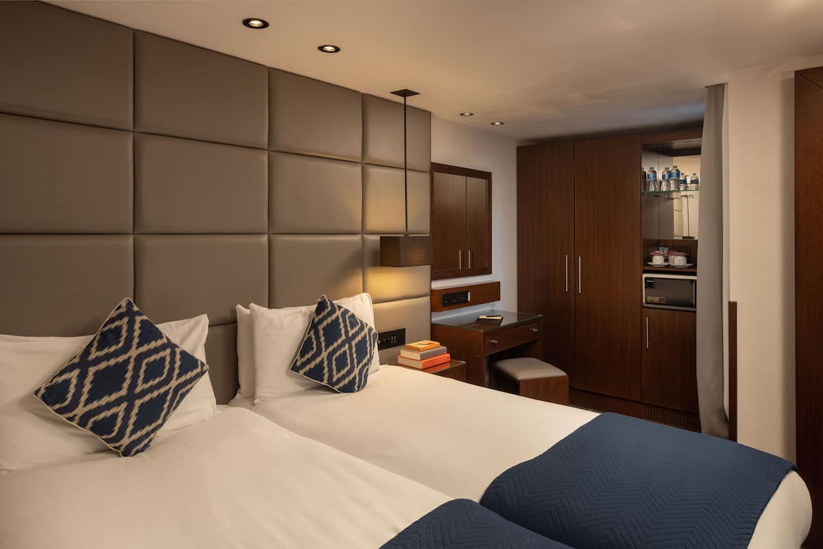 Una habitación de hotel con una cama grande, un escritorio y un armario.
