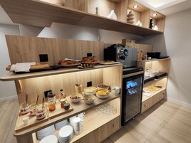 Una cocina moderna con estantes de madera, una cafetera y diversos alimentos.