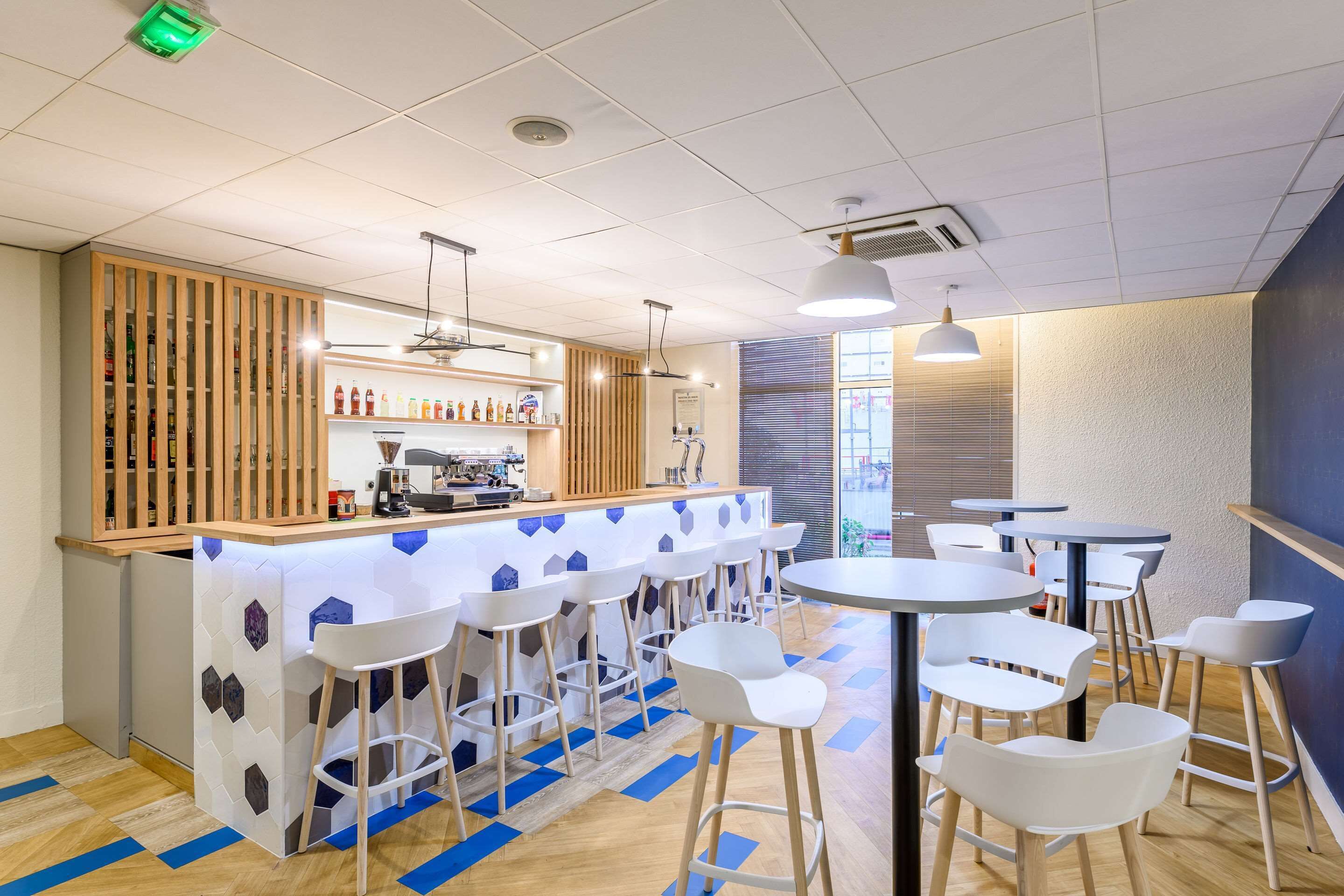 Un espace bar avec des tabourets, un comptoir et une machine à café.