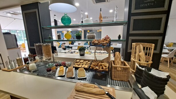Ein Frühstücksbuffet mit verschiedenen Speisen und einem Schneidebrett mit Messer.