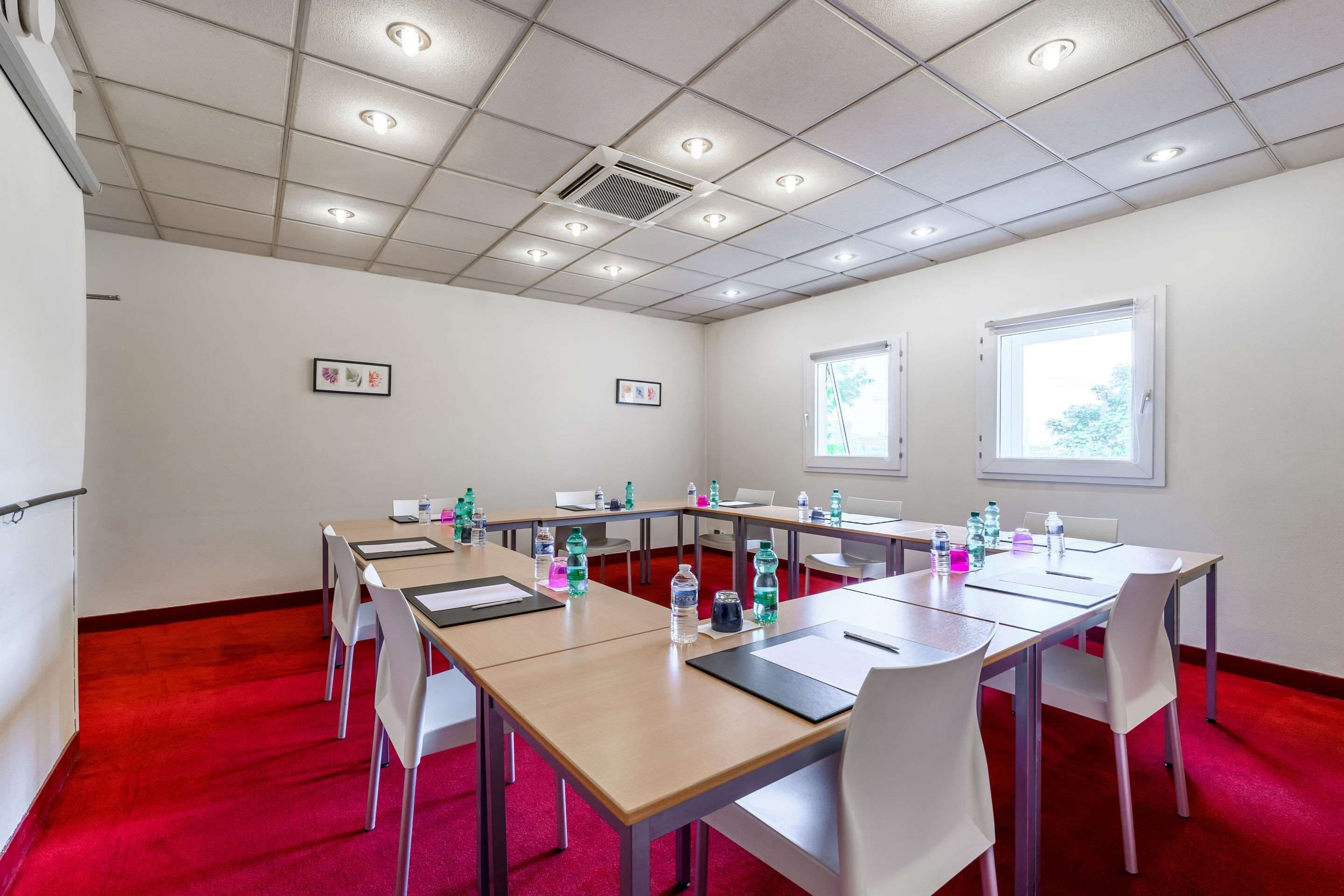 A conference room with a long table, chairs, and water bottles.