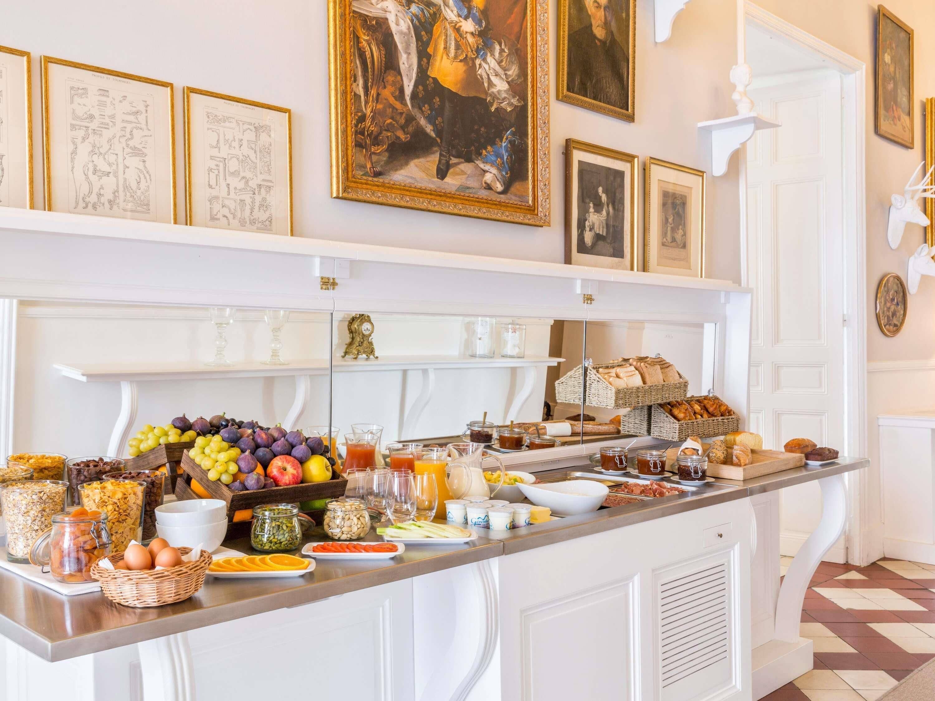 Un buffet de petit-déjeuner proposant une variété d’aliments et une sélection d’œuvres d’art encadrées accrochées au mur.