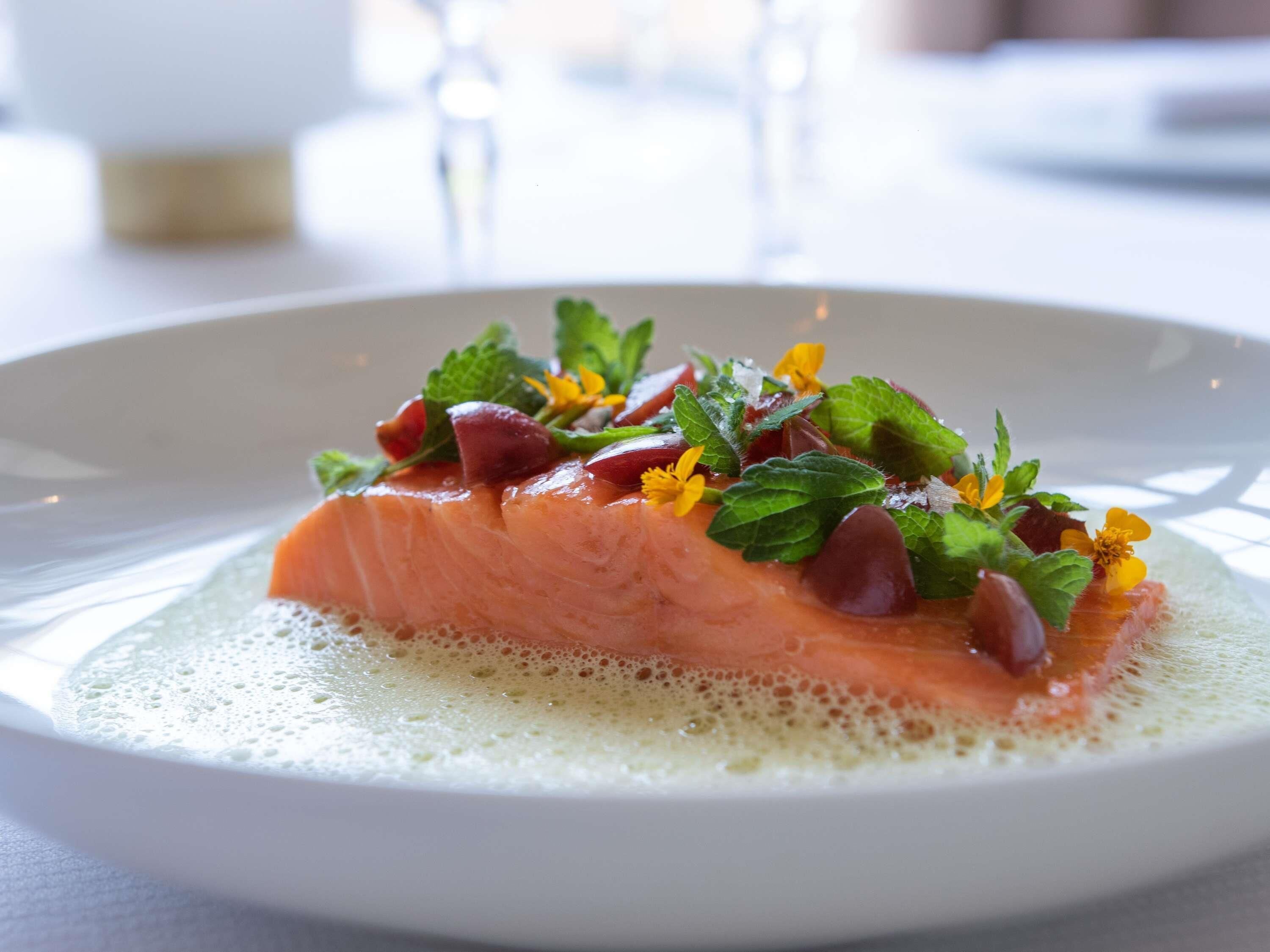 A plate of food with salmon and garnishes.