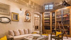 A cozy room with a sofa, armchairs, a coffee table, a bookshelf, and a horse head decoration. - Chateau de Mazan - Handwritten Collection (Mazan)
