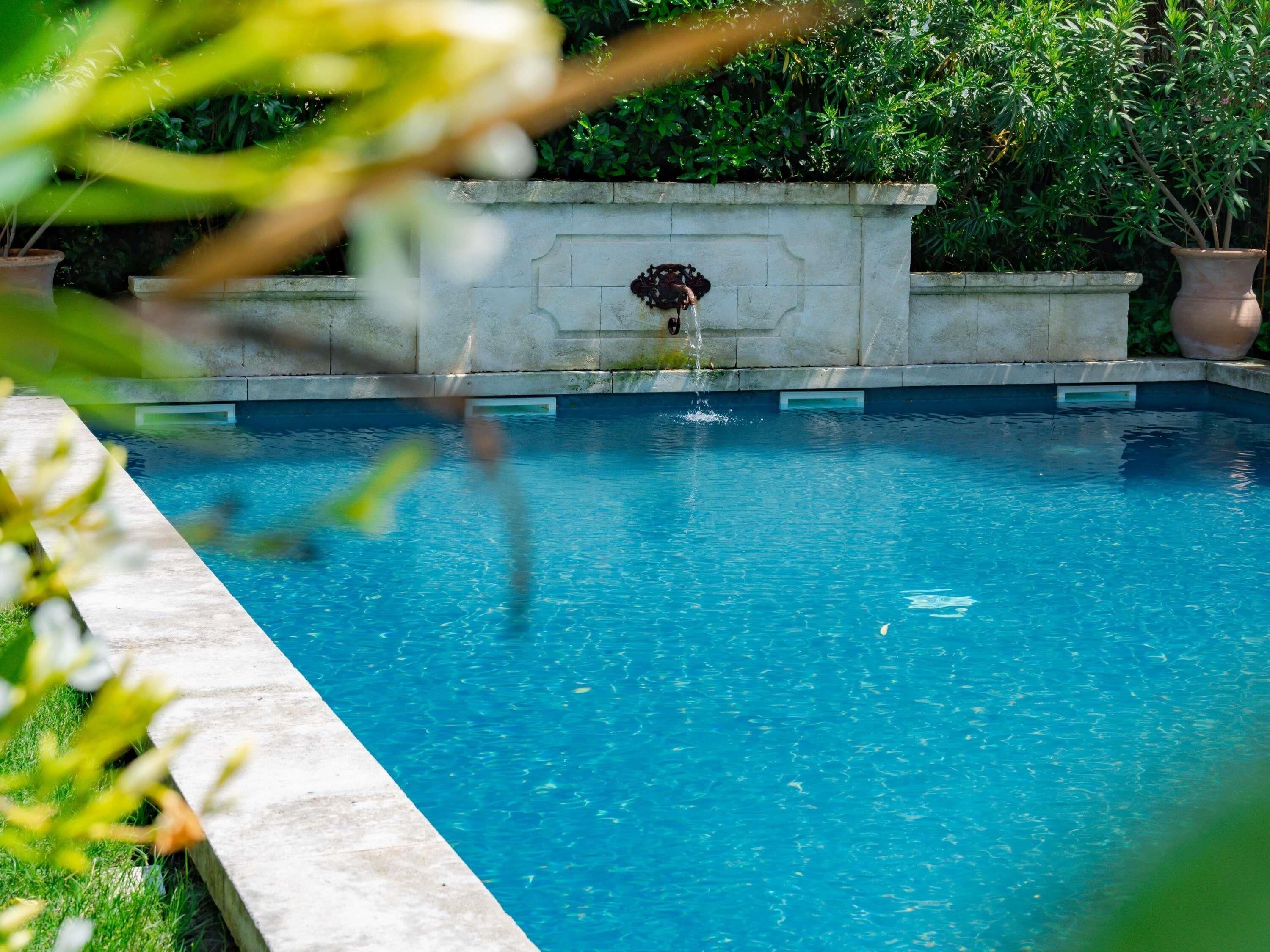Una piscina al aire libre, sillones reclinables de piscina