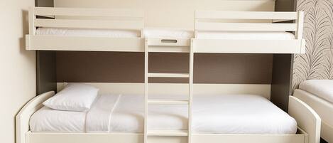 A bunk bed with a ladder, white bedding, and a grey carpet.