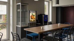 Une cuisine moderne dotée d’un îlot central, de tabourets de bar et d’un réfrigérateur.