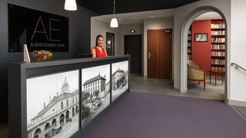 A reception desk with a black backdrop and a framed cityscape artwork.
