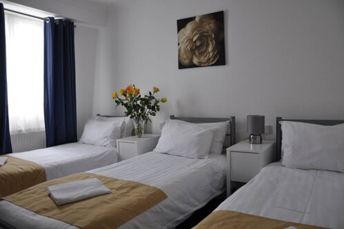 Habitación triple, baño compartido | Tabla de planchar con plancha, wifi gratis y ropa de cama 
