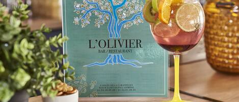 A menu from L'Olivier Bar/Restaurant with a tree design, a glass of drink with fruit slices, and a potted plant.