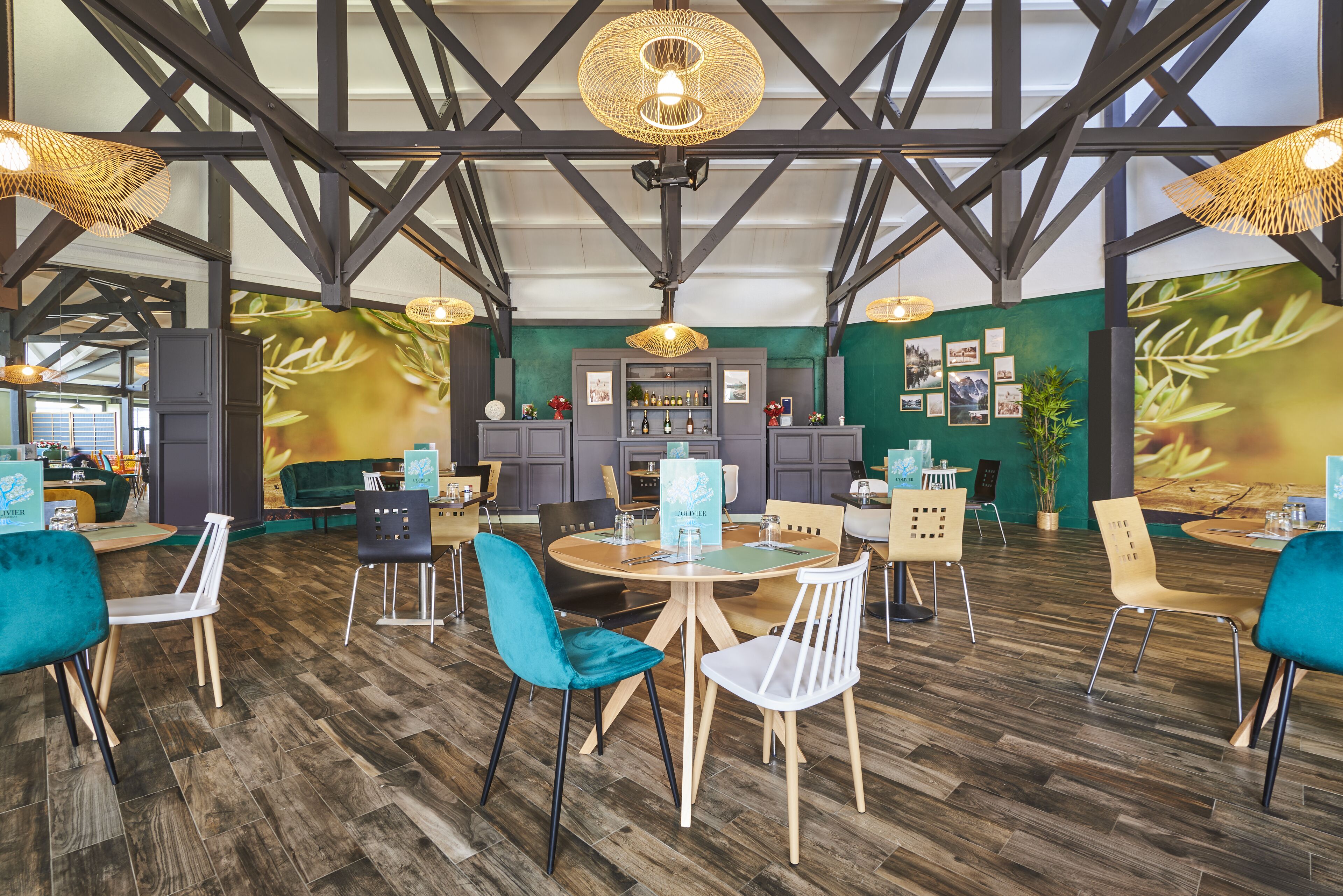 A spacious indoor area with high ceilings, wooden beams, and a bar area with seating.