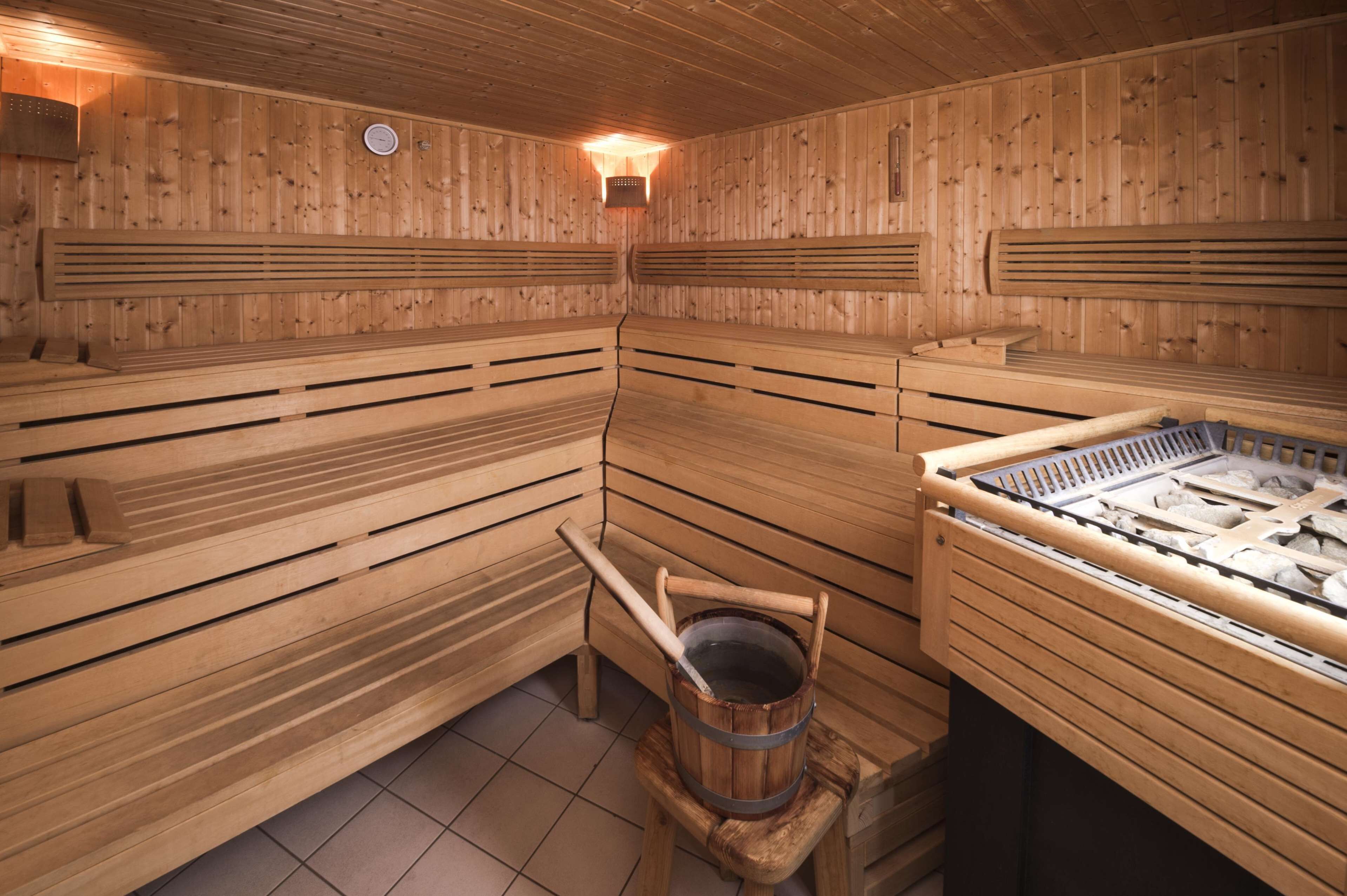 A wooden sauna with benches and a stone basin.