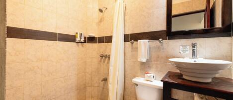 Un baño con ducha, inodoro y lavabo.
