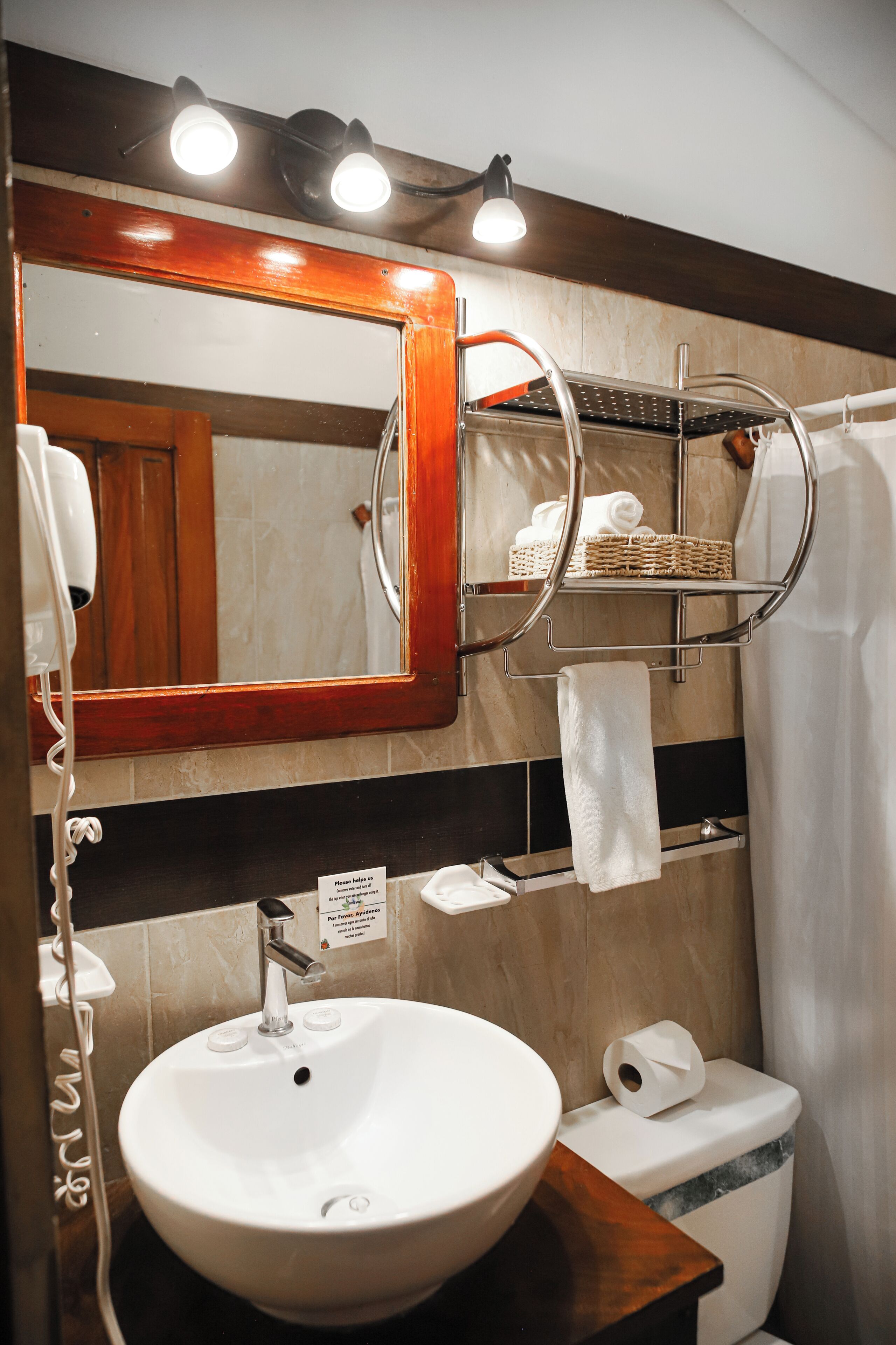 Une salle de bain équipée d’un lavabo, d’un miroir, d’un porte-serviettes et de toilettes.