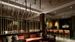 A modern bar area with a sofa, chairs, and a bar counter. - The Avenue Regent (Kanayannur)