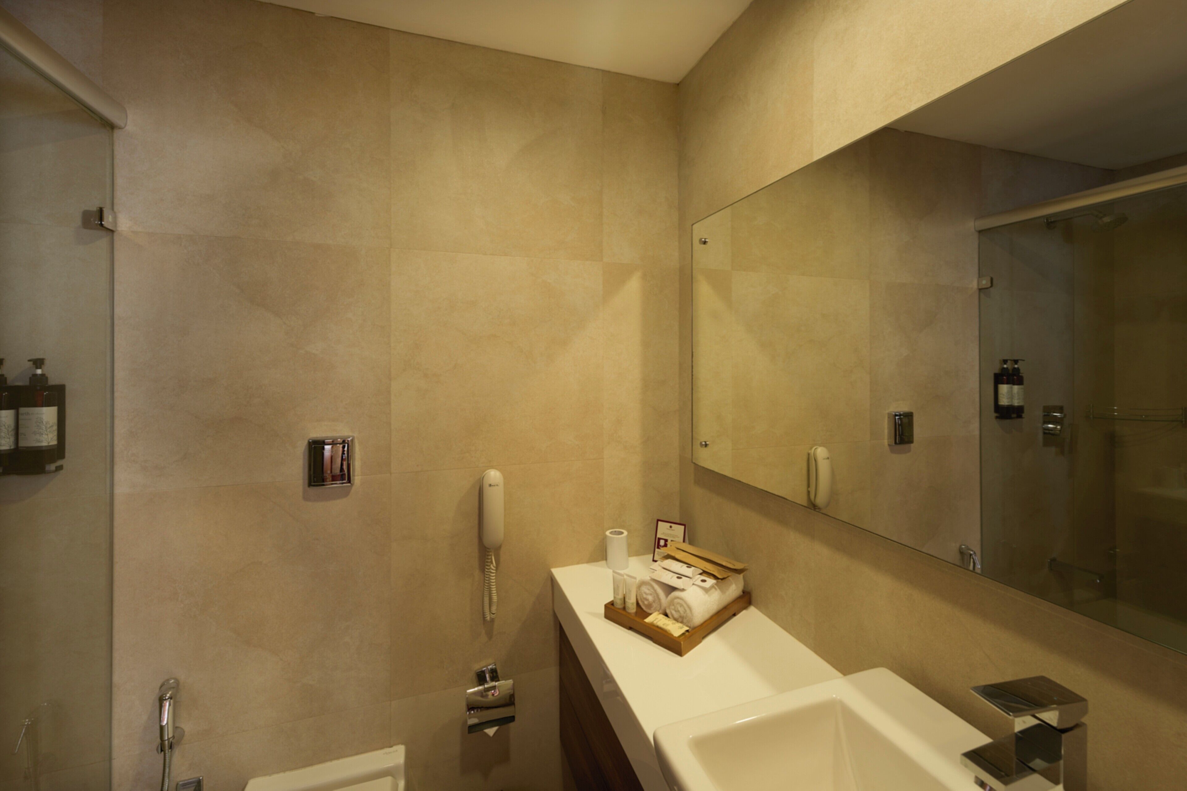 Un baño moderno con un espejo grande, una bañera y una zona de ducha.
