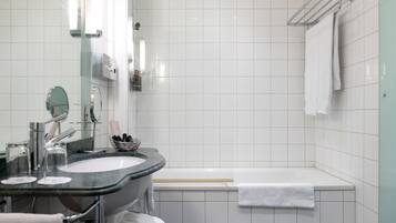 Un baño moderno con lavamanos, espejo y bañera.