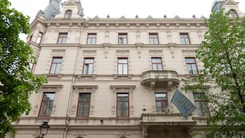 Un edificio histórico con detalles arquitectónicos ornamentales, múltiples ventanas y un balcón.