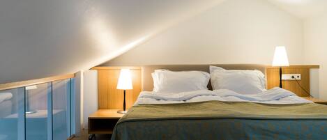 Una camera d'albergo con un letto, due lampade da comodino, un comodino e un mobile vetrina.