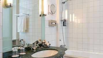 Un baño con lavamanos de mármol, un espejo, toallero, ducha y bañera.