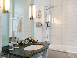 A bathroom with a marble sink, a mirror, a towel rack, a shower, and a bathtub.