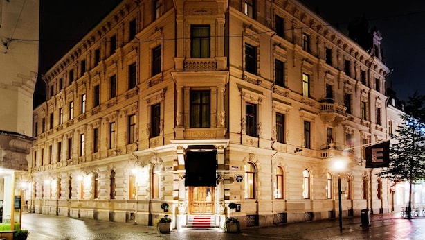 Ein historisches Gebäude im klassischen Architekturstil, mit einem markanten Eingangsbereich mit Treppen und einem großen Schild über der Tür.