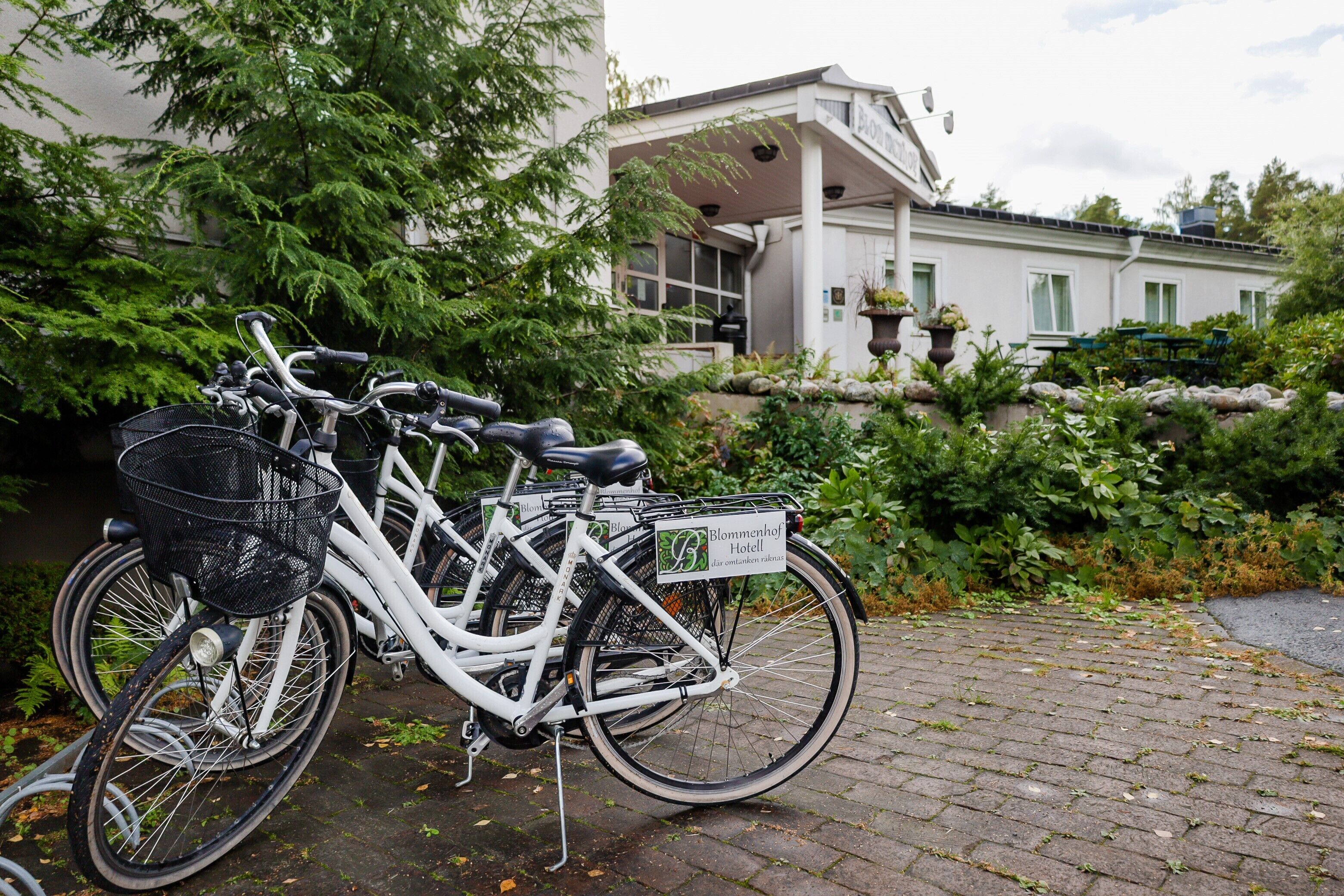 Una bicicleta estacionada frente a un edificio con un letrero que dice 'Blommenhof Hotel'.