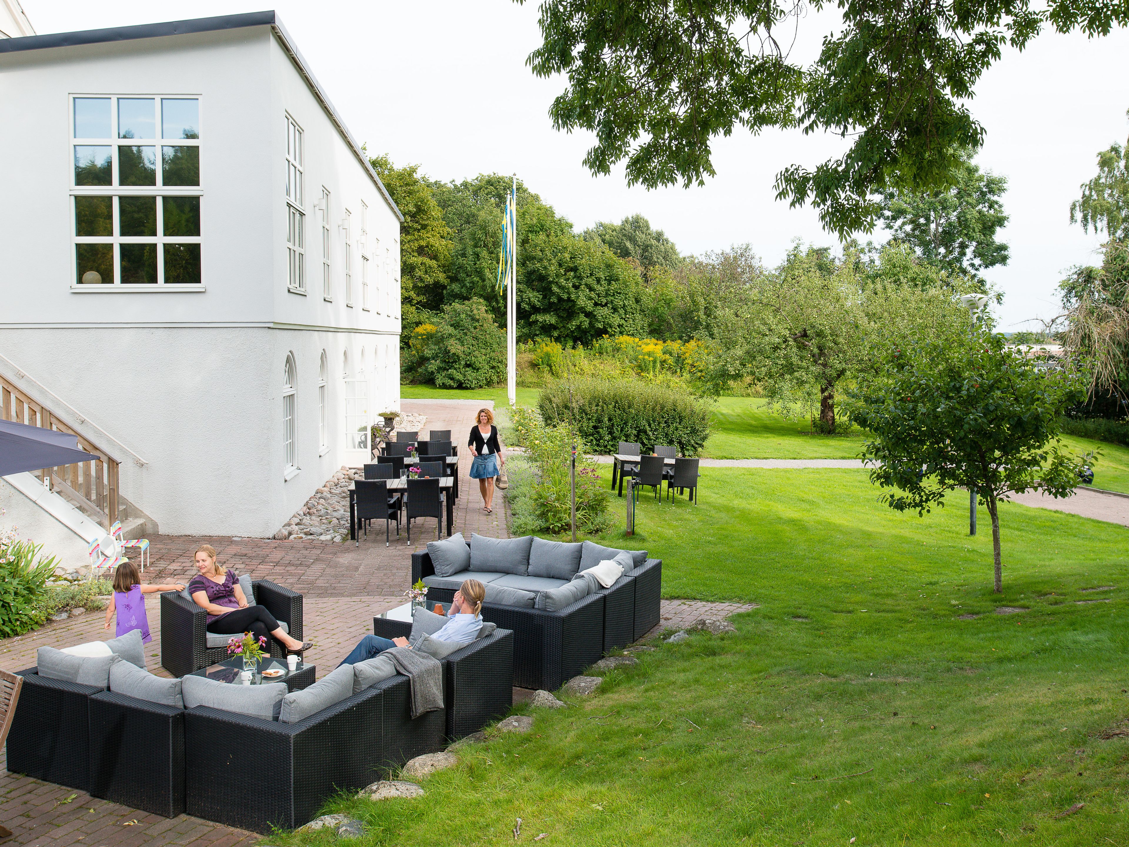 An outdoor seating area with wicker furniture, a patio table, and a flagpole.