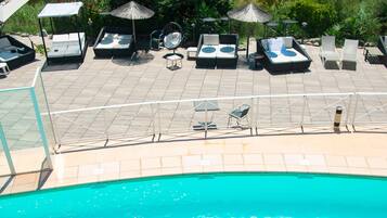 En säsongsöppen utomhuspool och solstolar