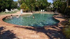 A swimming pool surrounded by palm trees and lounge chairs. - Bay Hideaway Resort (Eli Waters)
