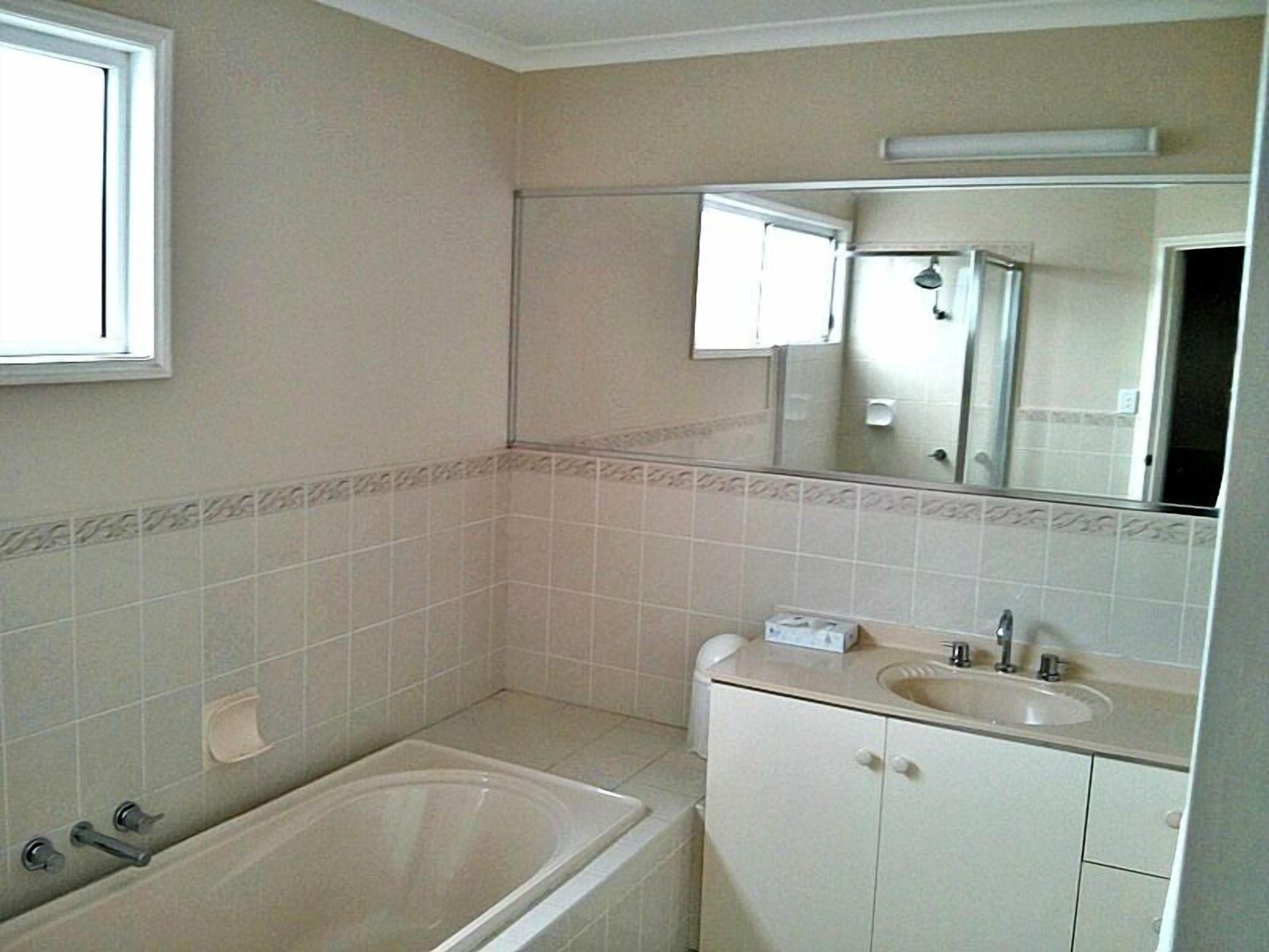 Un baño con bañera, lavamanos y espejo.