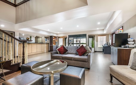 A spacious living area with a grey sofa, a coffee table, and a TV stand.