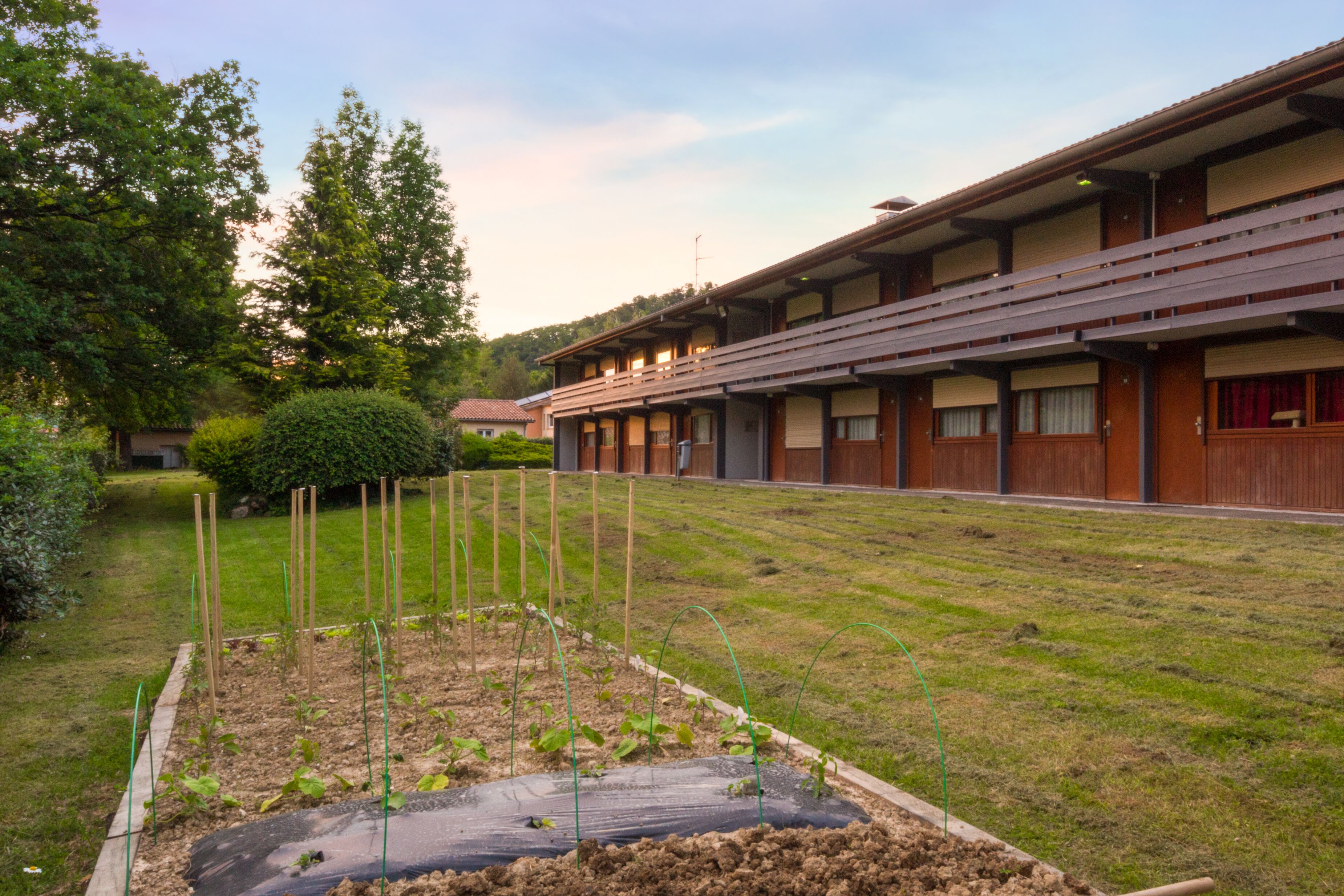 Un hôtel doté d’un jardin, comprenant des parterres surélevés et un petit étang.