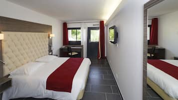 Een hotelkamer met een groot bed, een bureau en een spiegel.