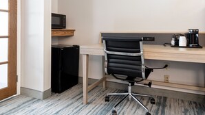 A small office space with a desk, a black office chair, a microwave, a coffee maker, and a refrigerator. - SureStay by Best Western Lewisville Dallas (Lewisville)