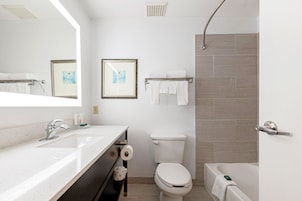A modern bathroom with a sink, toilet, and bathtub.