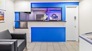 Un espace d’accueil avec un mur d’accent bleu, un comptoir et une enseigne Days Inn.