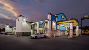 Un hôtel Days Inn au design moderne, avec un logo en forme d’étoile bien visible et une entrée bien éclairée.