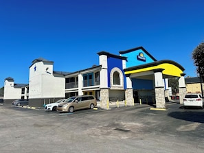 Welcome to Days Inn, featuring a unique architectural style with a prominent entrance and ample parking.