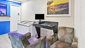 Une pièce comprenant un bureau, un ordinateur et deux chaises à motifs.