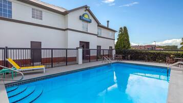 En sÀsongsöppen utomhuspool och solstolar