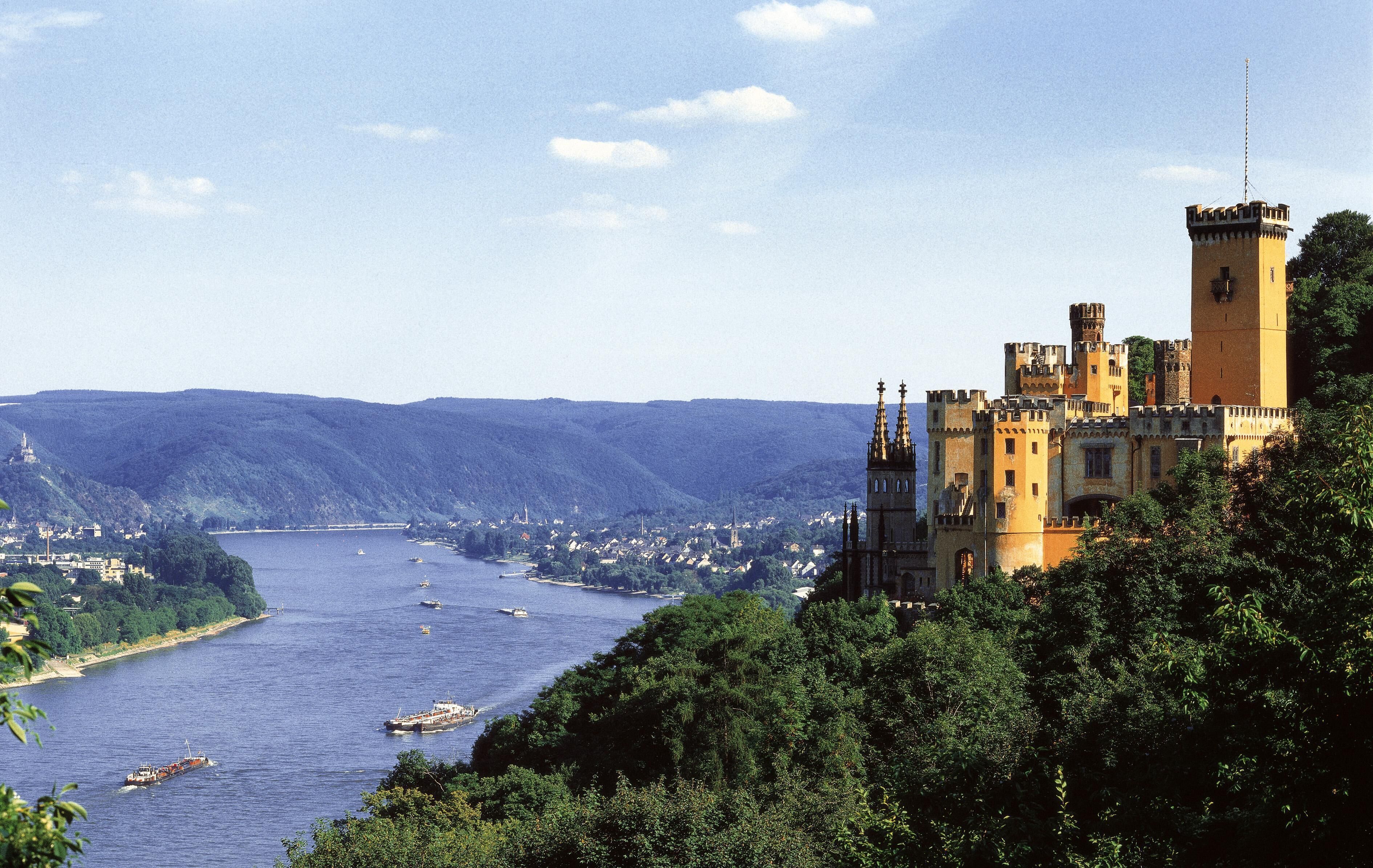 A castle with multiple towers overlooking a river.