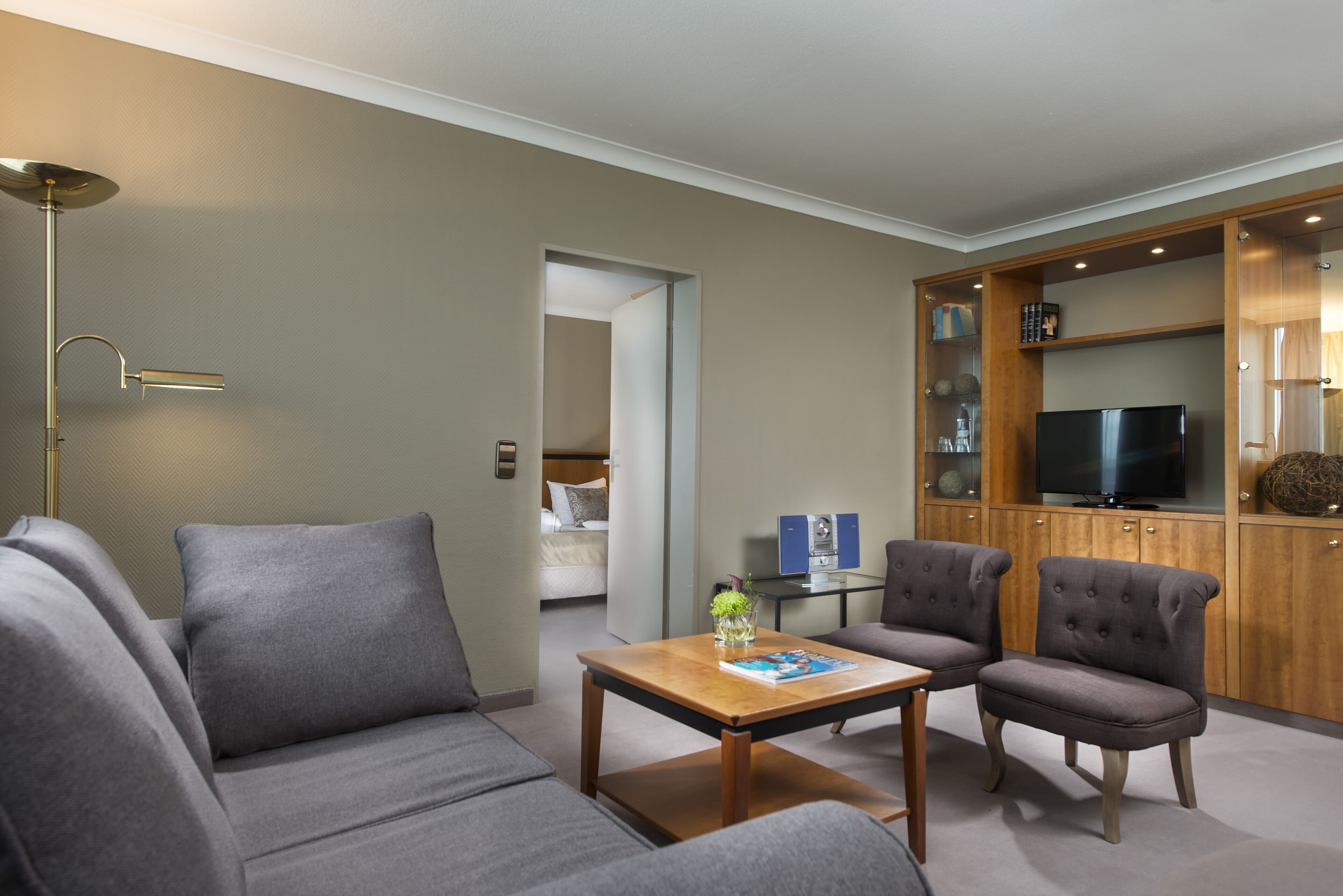 Una sala de estar moderna con un sofá, sillones, una mesa de centro y un televisor.