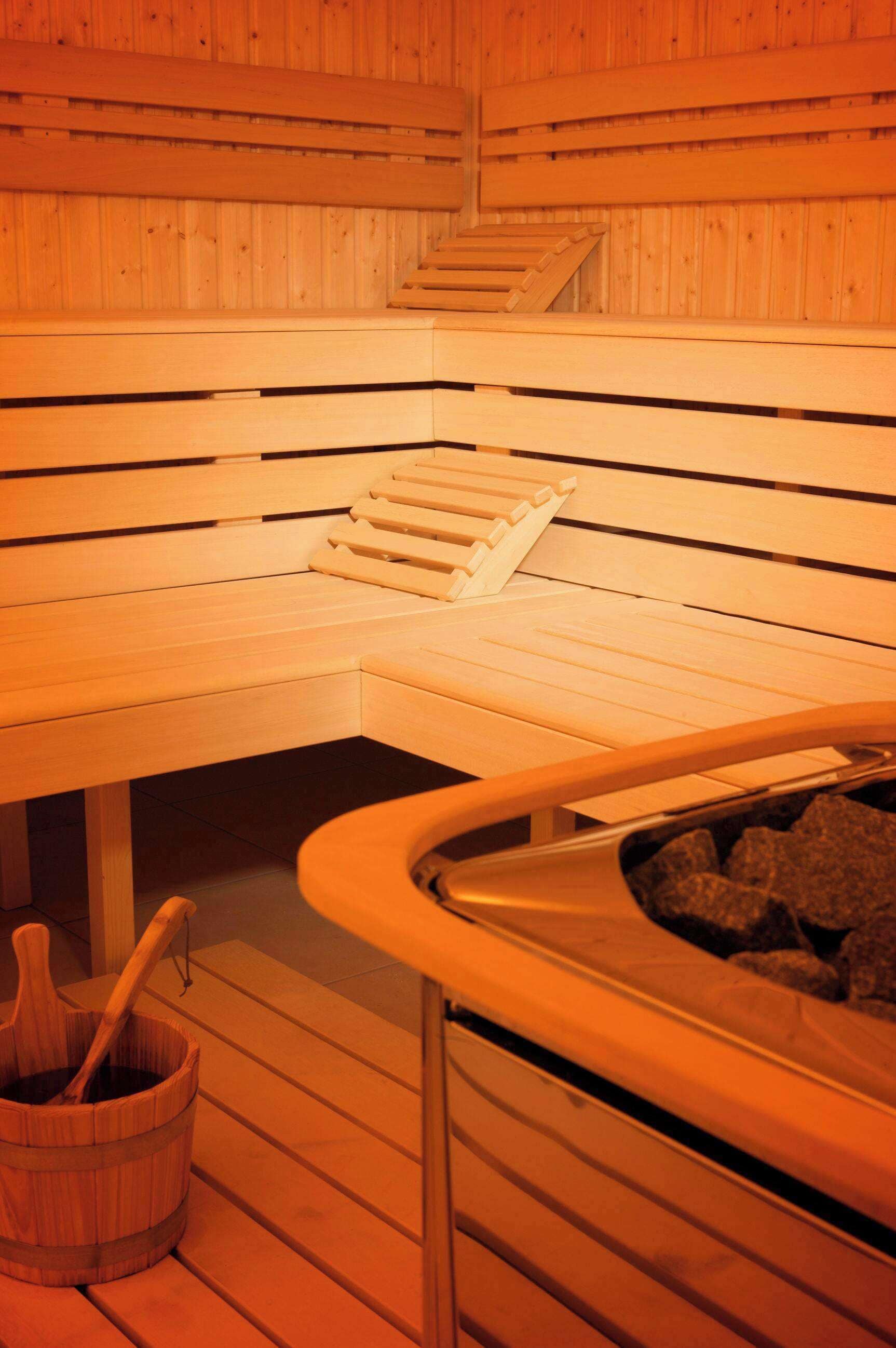 A wooden sauna with benches and a stone basin.