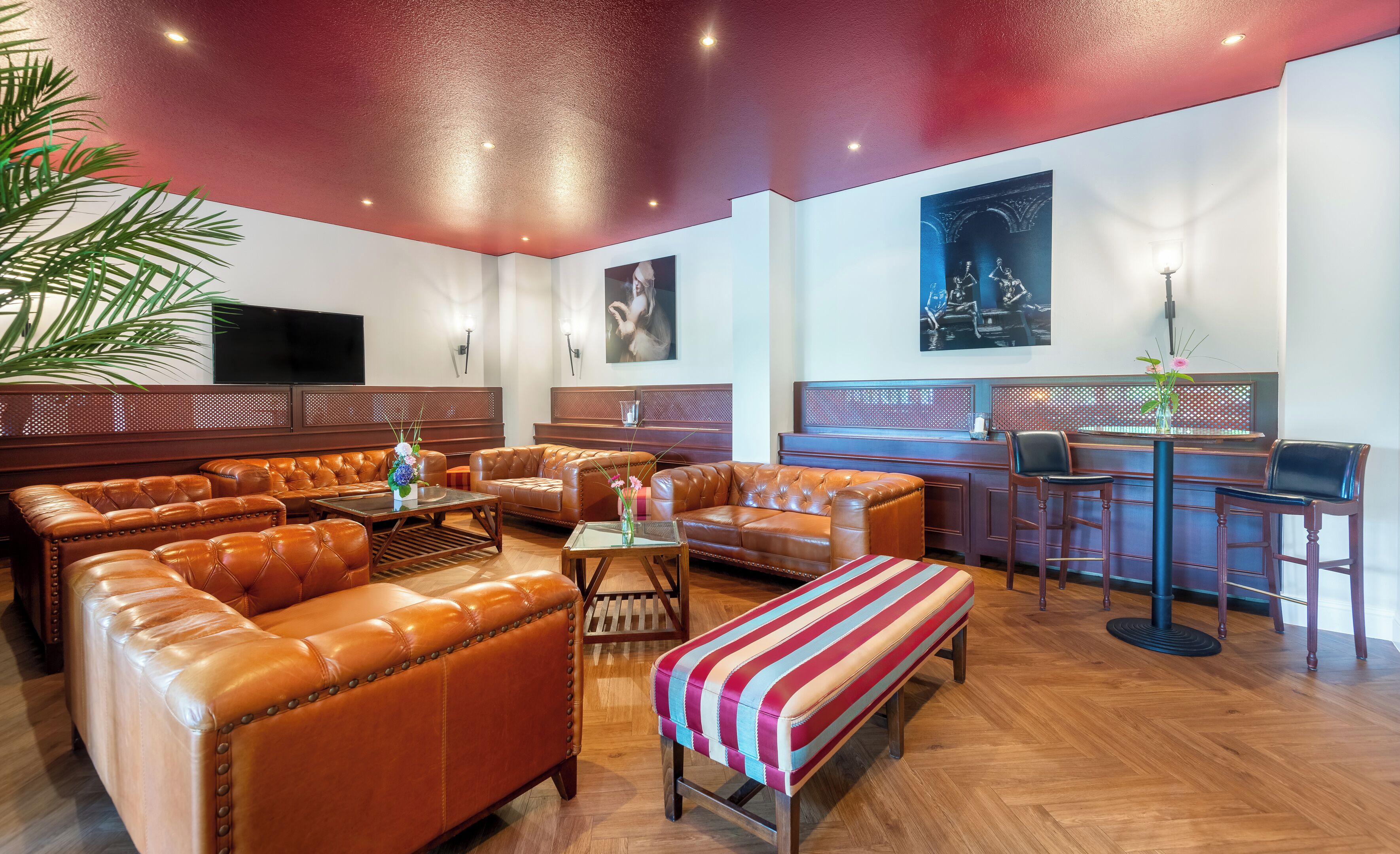 Ein großzügiger Lounge-Bereich mit Ledersofas, einer Bar und einem großen Bildschirm.