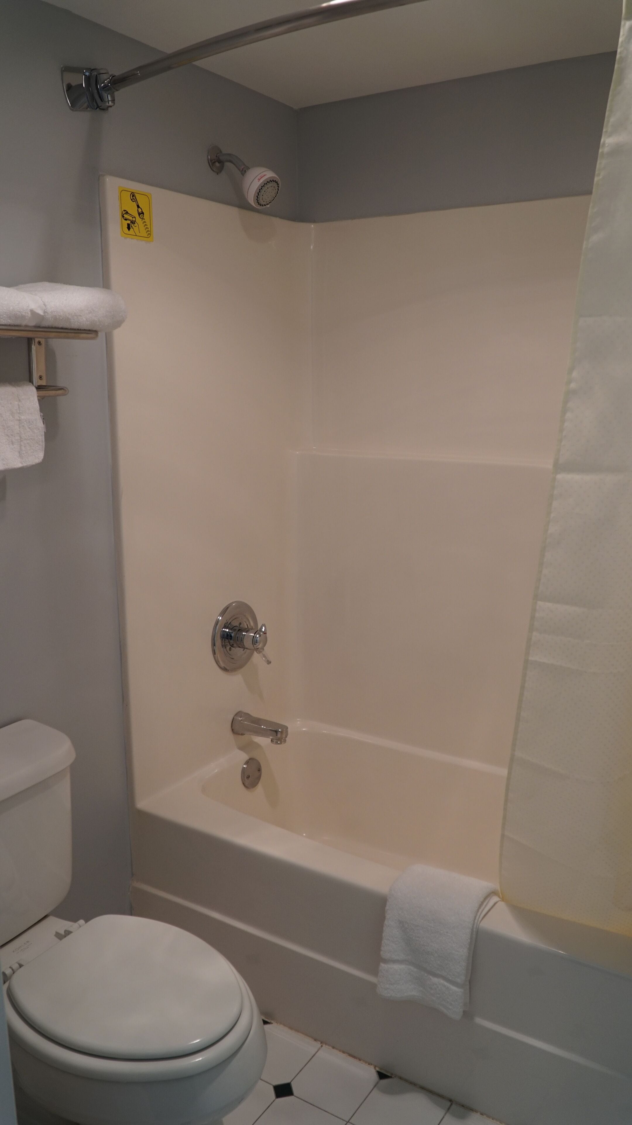 A bathroom with a bathtub, toilet, and shower curtain.